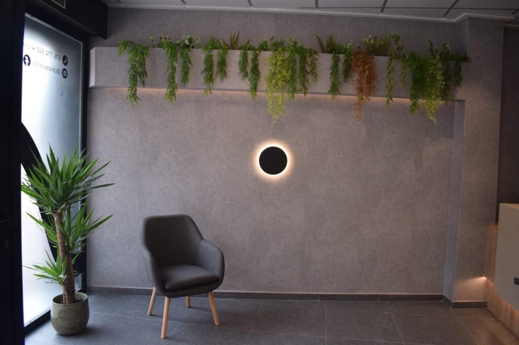 Sala de espera de la Clínica Avence, con butaca, plantas y luz cálida